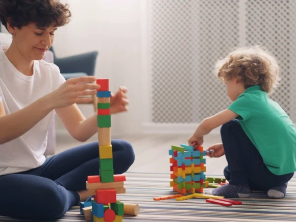 child playing blocks with teacher